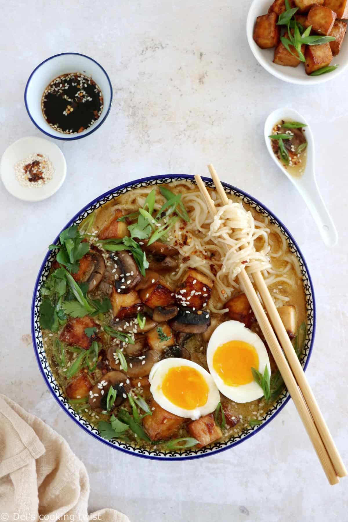 Here's a delicious tahini miso ramen with crispy tofu, sautéed mushrooms, soft boiled eggs, and a broth loaded with umami and slightly spicy flavors.