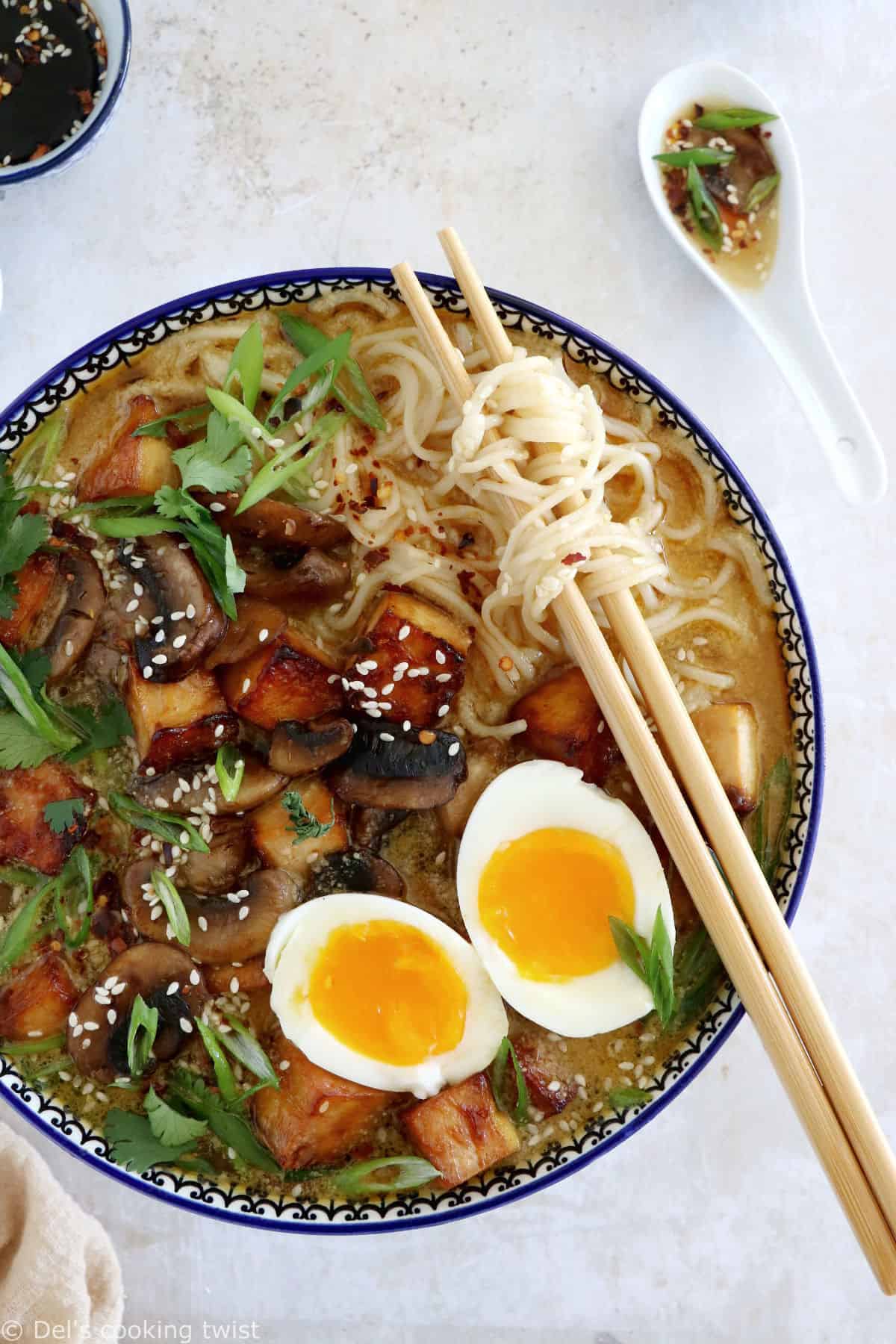 Here's a delicious tahini miso ramen with crispy tofu, sautéed mushrooms, soft boiled eggs, and a broth loaded with umami and slightly spicy flavors.