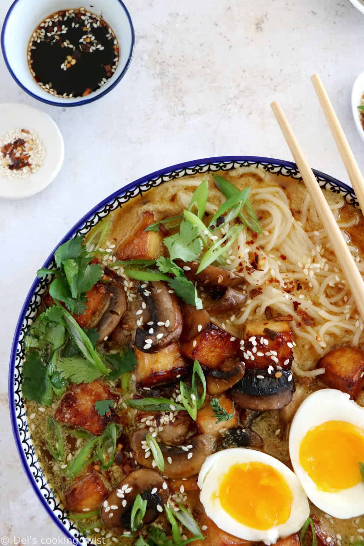 Here's a delicious tahini miso ramen with crispy tofu, sautéed mushrooms, soft boiled eggs, and a broth loaded with umami and slightly spicy flavors.