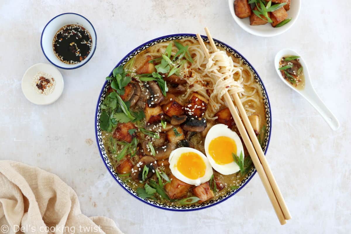 Here's a delicious tahini miso ramen with crispy tofu, sautéed mushrooms, soft boiled eggs, and a broth loaded with umami and slightly spicy flavors.