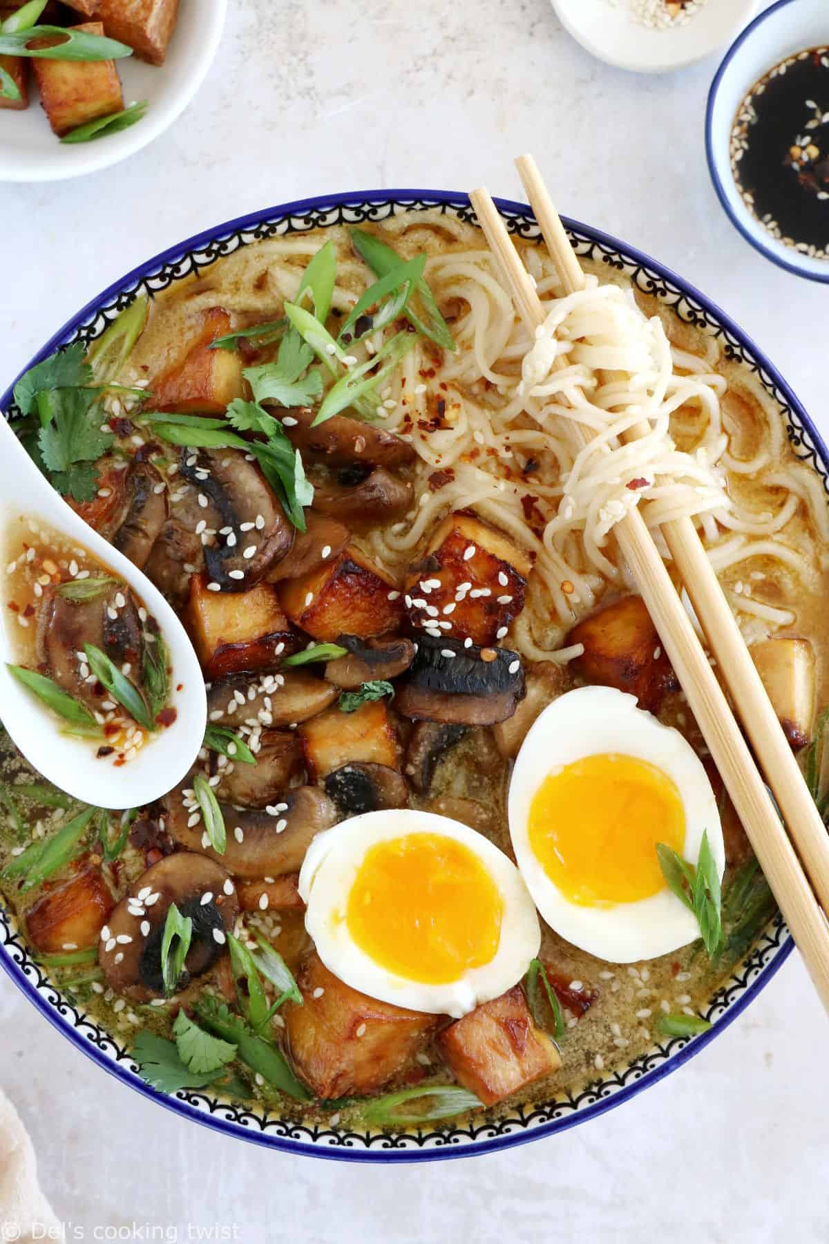 Here's a delicious tahini miso ramen with crispy tofu, sautéed mushrooms, soft boiled eggs, and a broth loaded with umami and slightly spicy flavors.