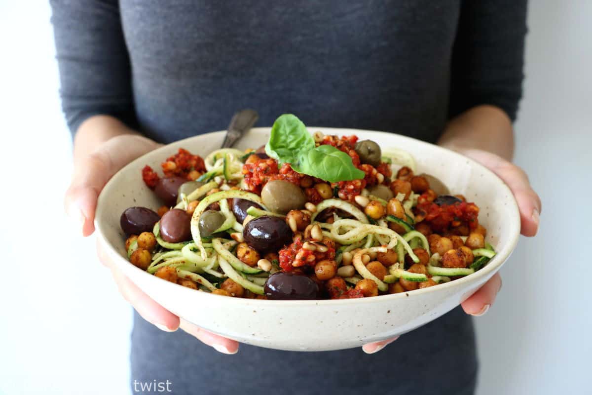 These Mediterranean chickpea zoodles burst with summer flavors. Both vegan and gluten-free, this healthy dish features some zucchini noodles, olives and roasted chickpeas, tossed in a delicious homemade sun-dried tomato sauce.