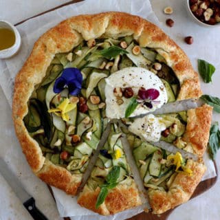 This beautiful zucchini galette is prepared with honey zucchini ribbons, toasted hazelnuts, and some burrata cheese bursting with refreshing flavors.