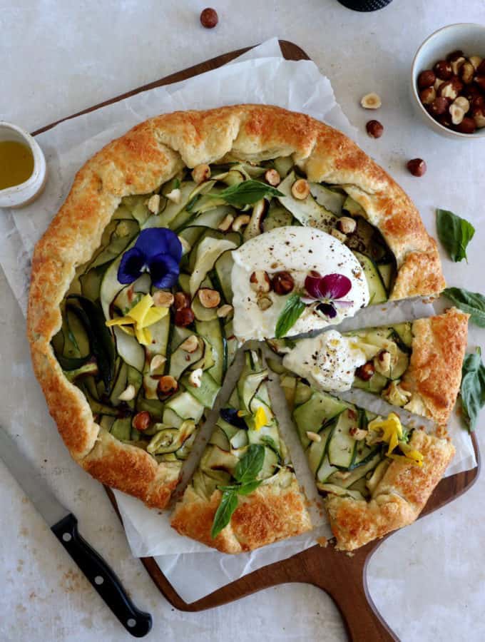 This beautiful zucchini galette is prepared with honey zucchini ribbons, toasted hazelnuts, and some burrata cheese bursting with refreshing flavors.
