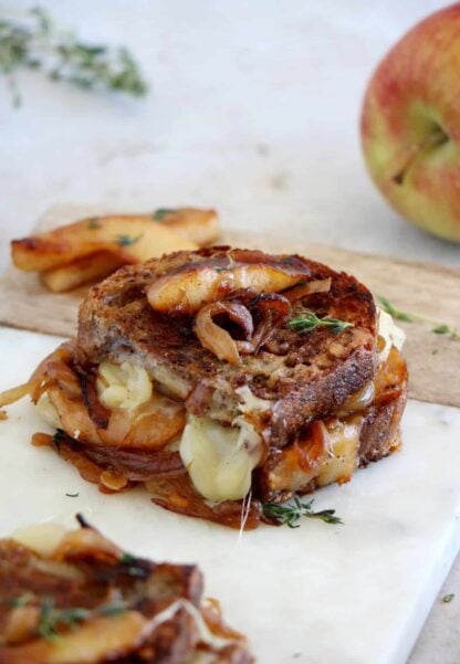 Apple and French Onion Grilled Cheese is a gourmet grilled cheese sandwich prepared with cheddar, caramelized onions and some cooked apples.