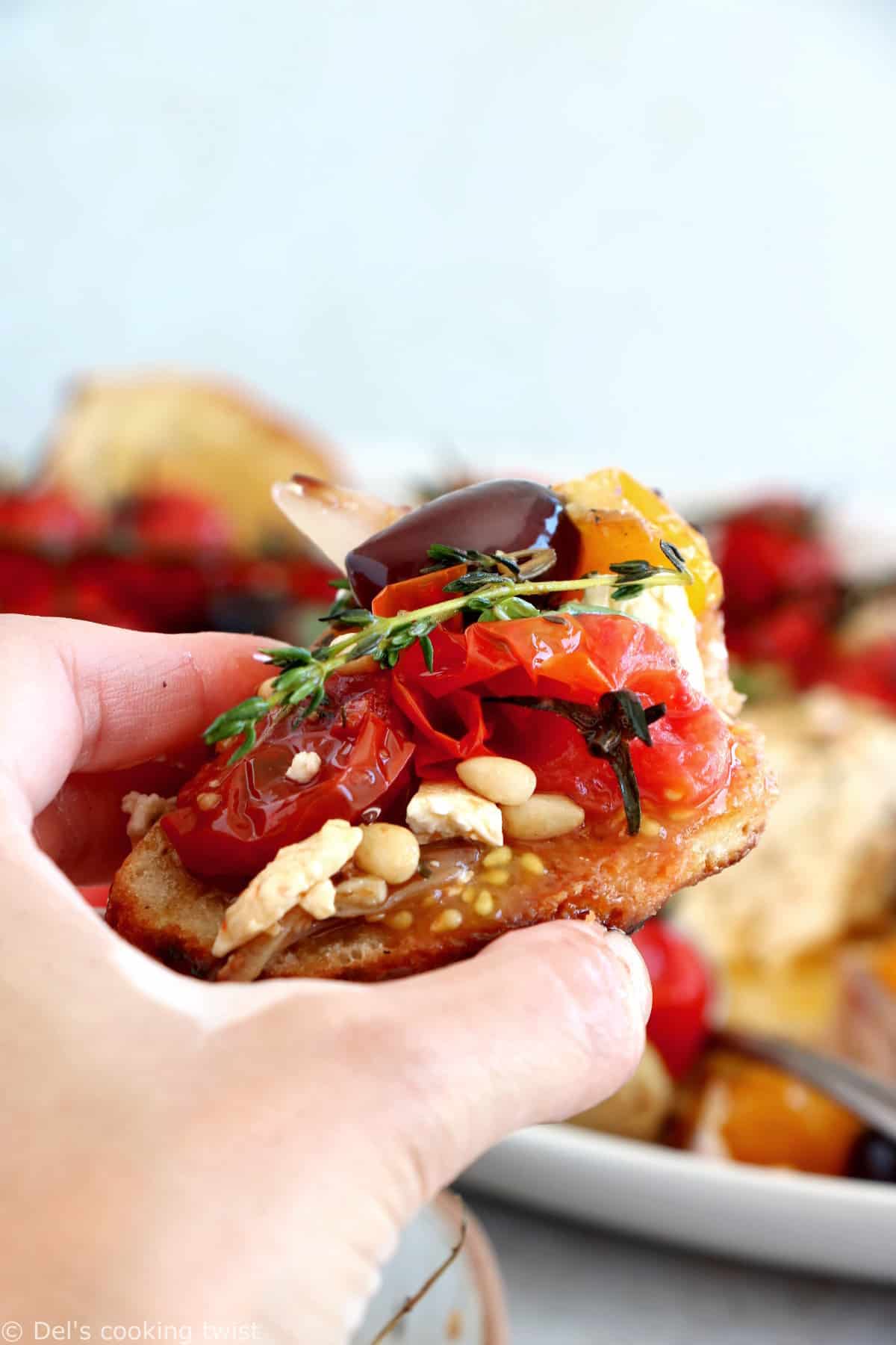 Découvrez ce plat de "baked feta", qui consiste en de la feta rôtie au four avec des tomates cerises confites et des olives marinées dans un mélange d'huile d'olive et d'herbes.