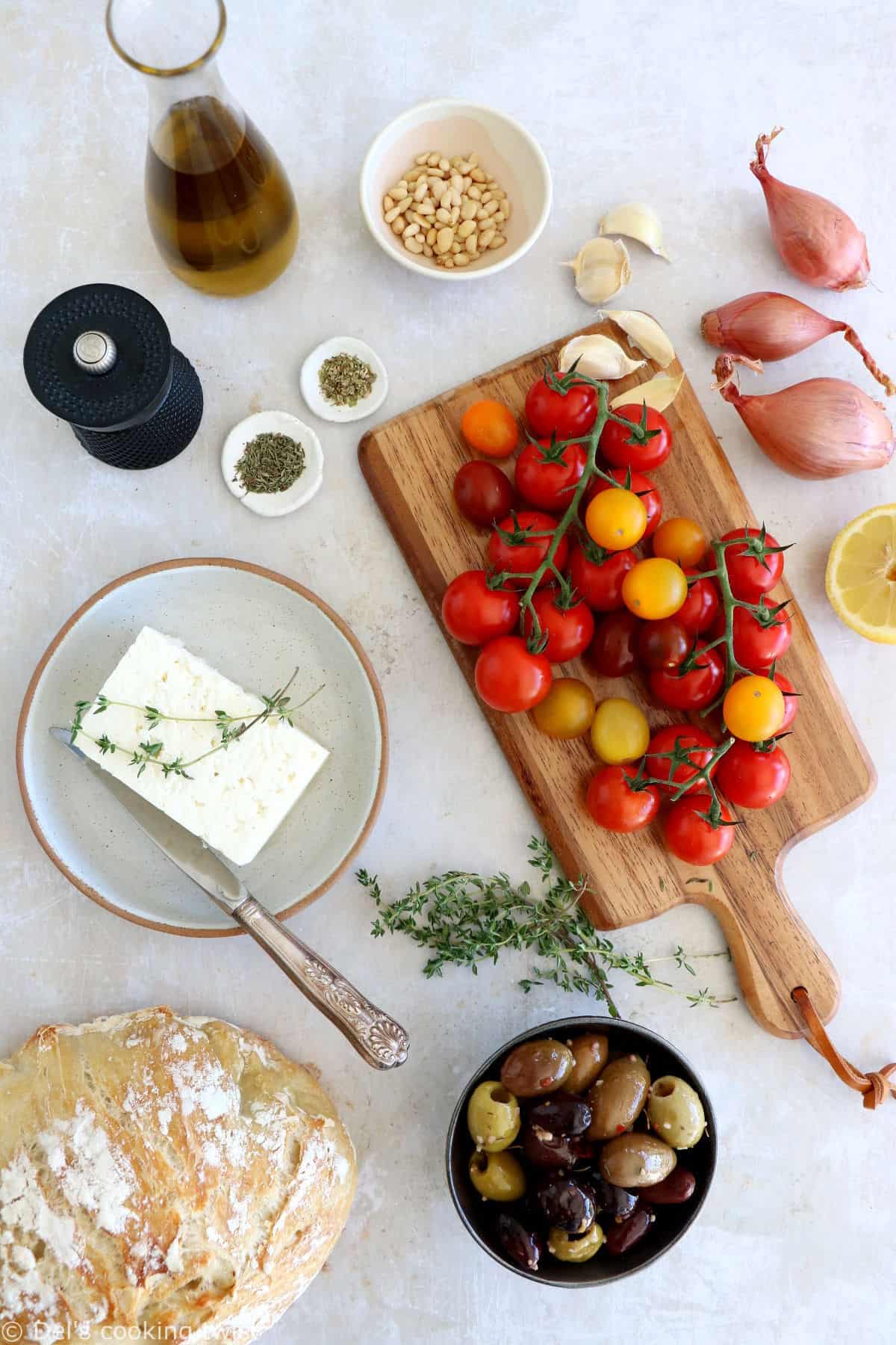 Découvrez ce plat de "baked feta", qui consiste en de la feta rôtie au four avec des tomates cerises confites et des olives marinées dans un mélange d'huile d'olive et d'herbes.