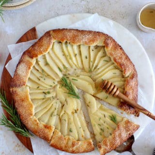 This rosemary honey pear galette is an easy pear tart recipe, featuring an irresistible flaky crust and some juicy pears infused in a rosemary honey syrup.