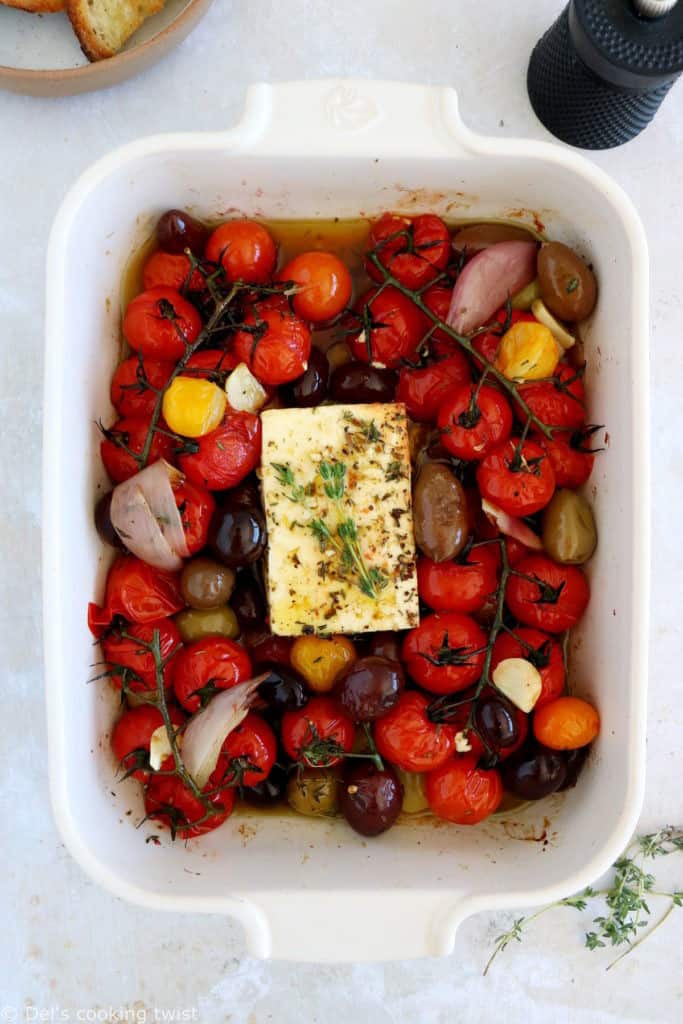 Découvrez ce plat de "baked feta", qui consiste en de la feta rôtie au four avec des tomates cerises confites et des olives marinées dans un mélange d'huile d'olive et d'herbes.