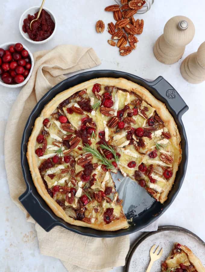 This cranberry brie tart prepared with a puff pastry makes for a lovely festive starter for the holidays. It's warm, comforting, and loaded with melting cheese and tangy cranberries.