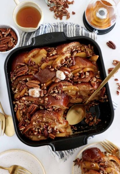 Baked Apple Pecan French Toast is the ultimate family breakfast, just perfect to feed a crowd. Both soft and crunchy, it features some thick challah bread slices, baked apples with a splash of whiskey, and an irresistible pecan-sugar mixture.