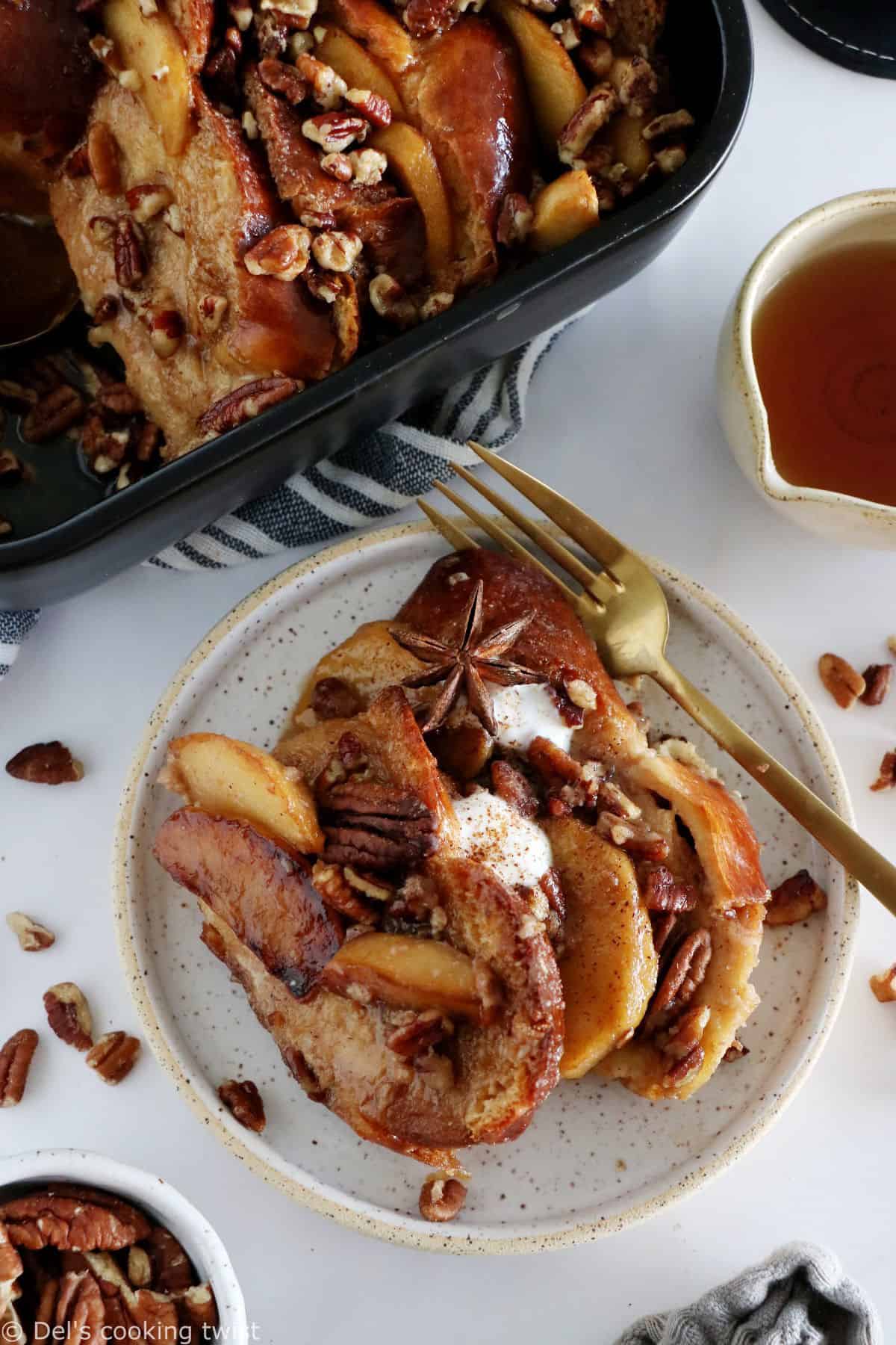 Baked Apple Pecan French Toast is the ultimate family breakfast, just perfect to feed a crowd. Both soft and crunchy, it features some thick challah bread slices, baked apples with a splash of whiskey, and an irresistible pecan-sugar mixture.