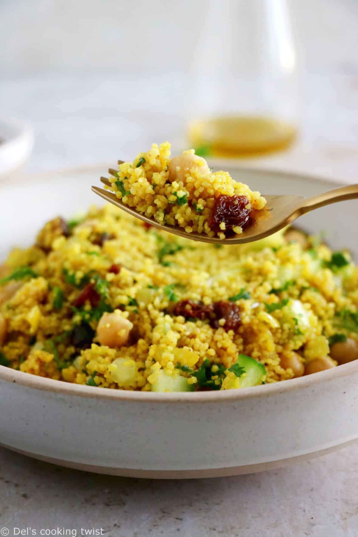 This Moroccan-inspired chickpea couscous salad consists in a delicious couscous flavored with ras el hanout, golden raisins, chickpeas and fresh herbs.