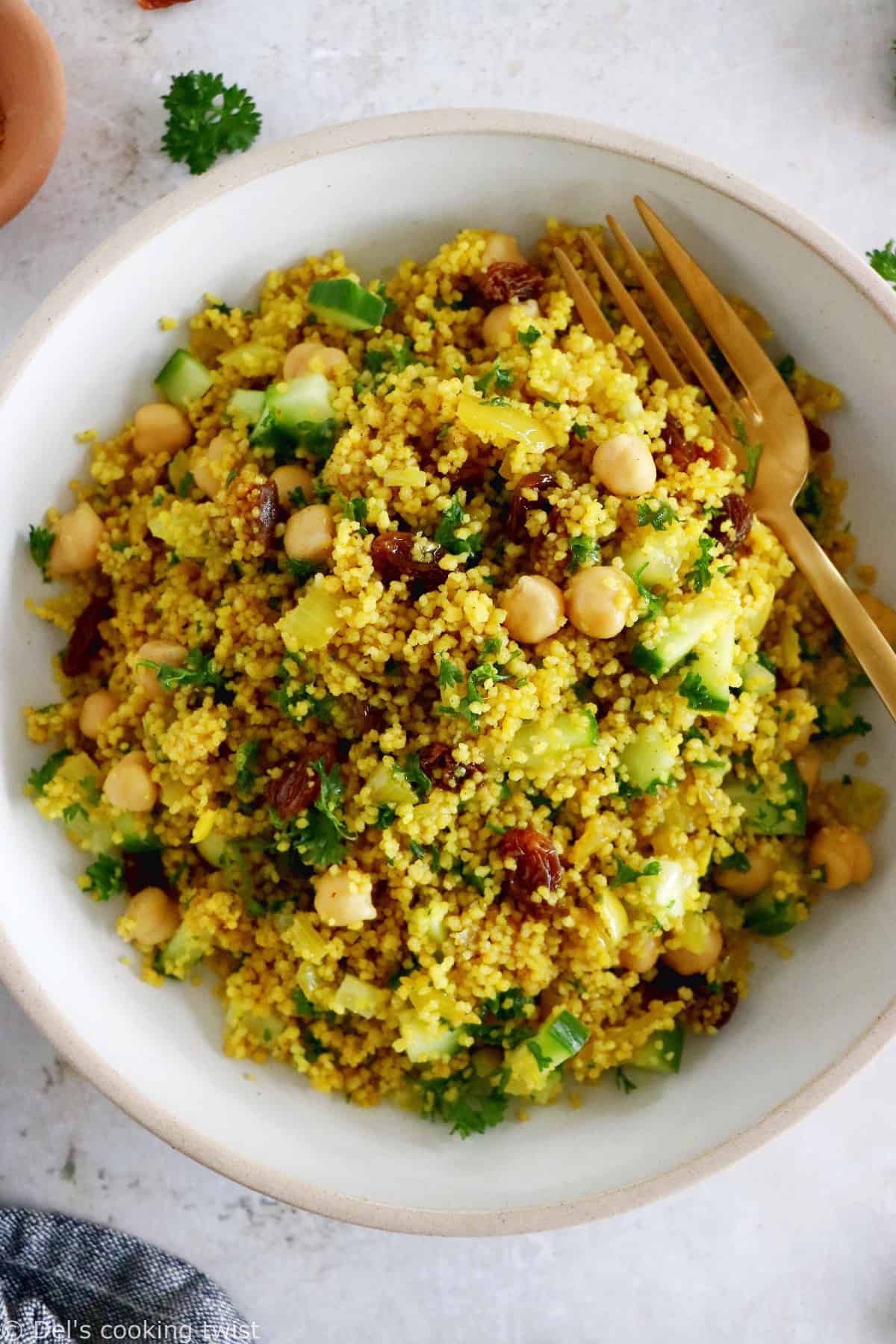 This Moroccan-inspired chickpea couscous salad consists in a delicious couscous flavored with ras el hanout, golden raisins, chickpeas and fresh herbs.