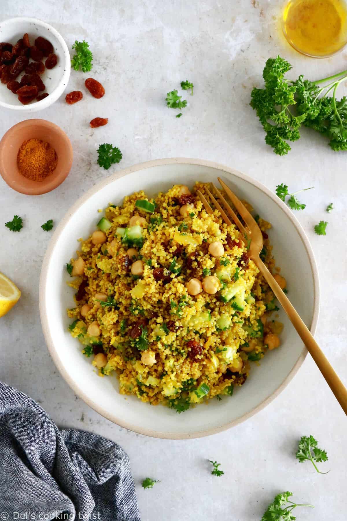 This Moroccan-inspired chickpea couscous salad consists in a delicious couscous flavored with ras el hanout, golden raisins, chickpeas and fresh herbs.