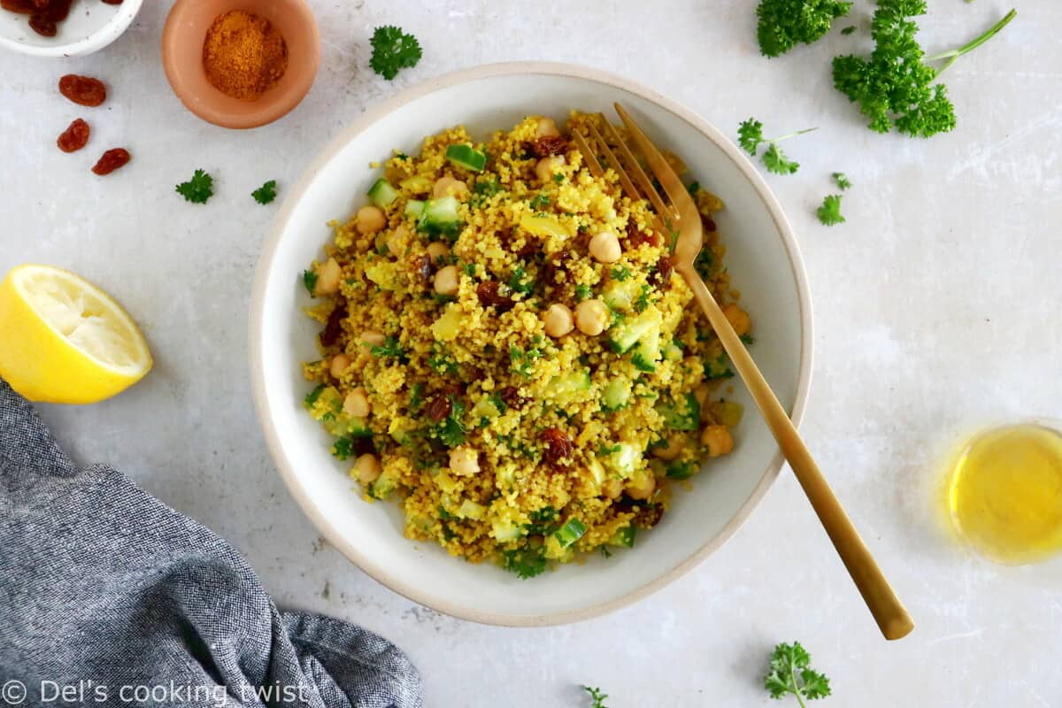 This Moroccan-inspired chickpea couscous salad consists in a delicious couscous flavored with ras el hanout, golden raisins, chickpeas and fresh herbs.