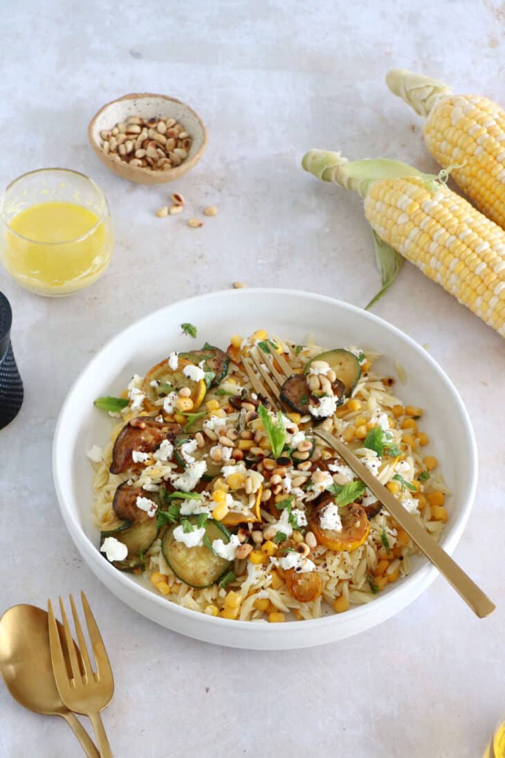This corn and zucchini orzo salad with goat cheese is tossed together with a cumin vinaigrette and some mint for a very refreshing touch.