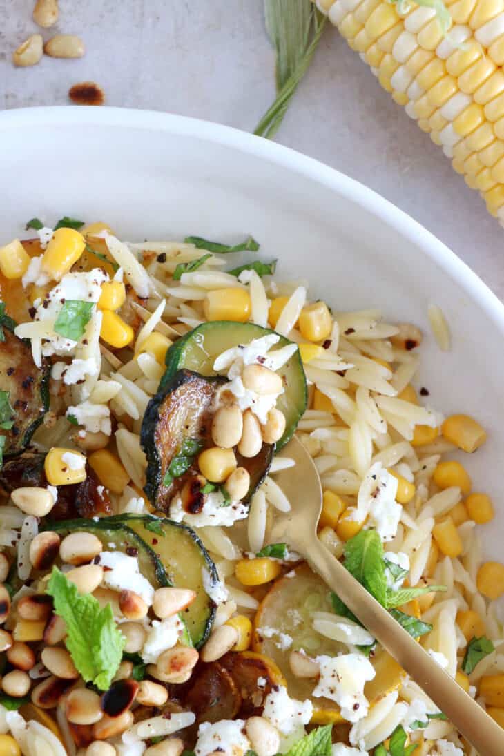 This corn and zucchini orzo salad with goat cheese is tossed together with a cumin vinaigrette and some mint for a very refreshing touch.