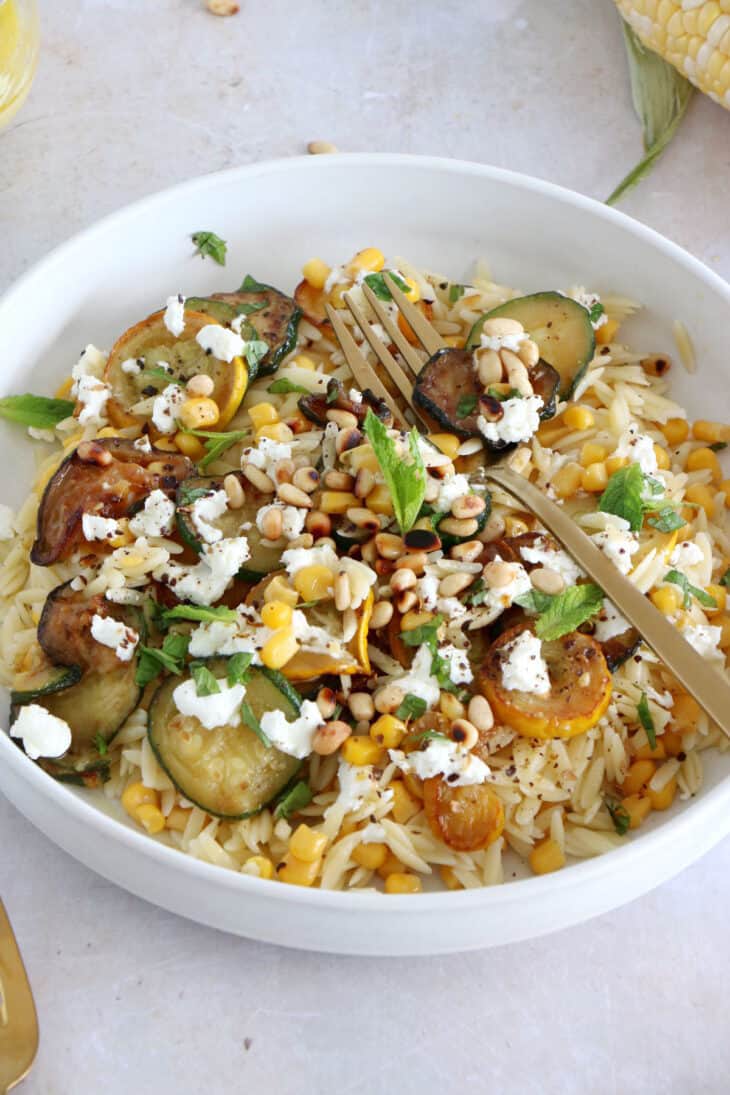 This corn and zucchini orzo salad with goat cheese is tossed together with a cumin vinaigrette and some mint for a very refreshing touch.