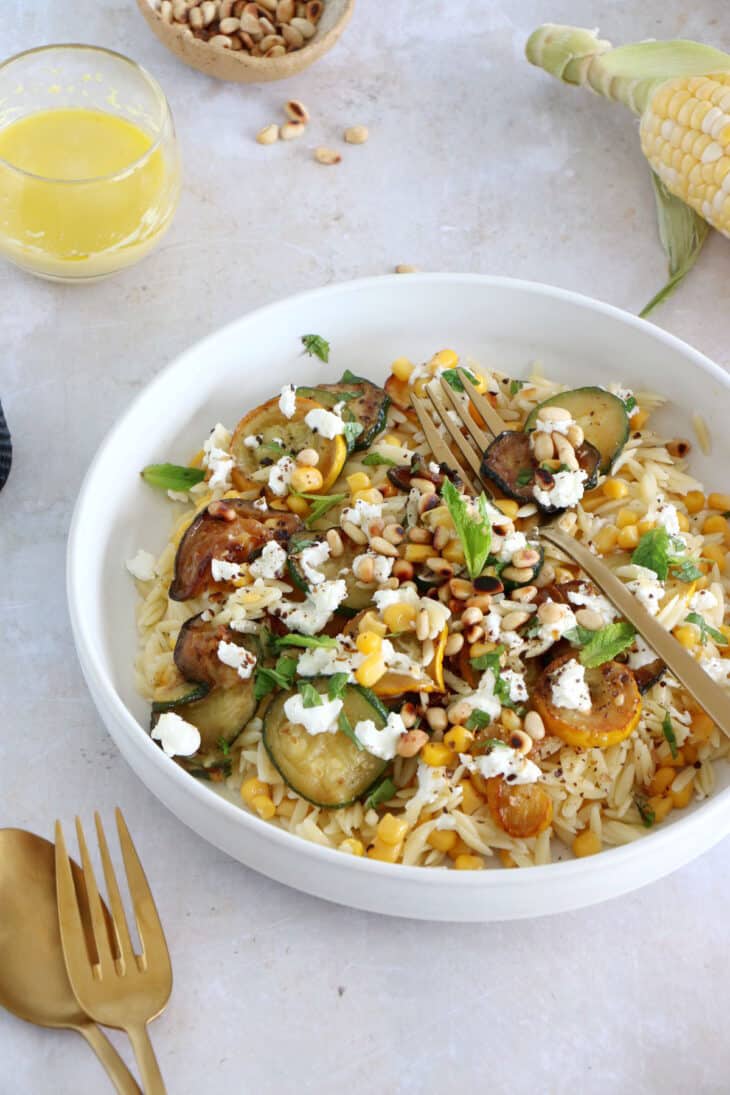 This corn and zucchini orzo salad with goat cheese is tossed together with a cumin vinaigrette and some mint for a very refreshing touch.