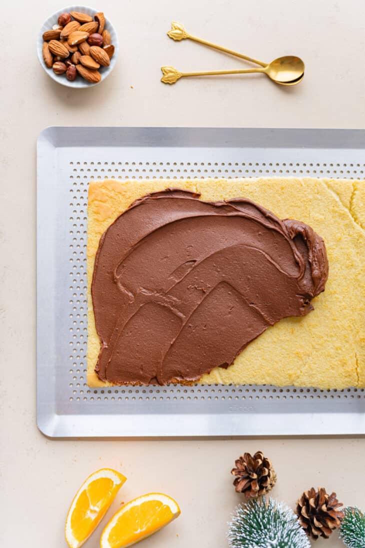 This chocolate orange yule log (or bûche de Noël in French) is a traditional Christmas dessert in France. It consists of a light sponge cake, subtly flavored with orange, and a generous chocolate ganache.