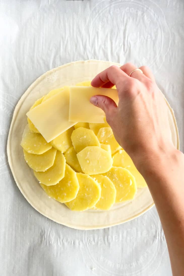 Cette tourte aux pommes de terre est née de l'idée d'une galette des rois salée. On y retrouve des fines lamelles de pommes de terre, du poireau et du Comté entre deux disques de pâte feuilletée.