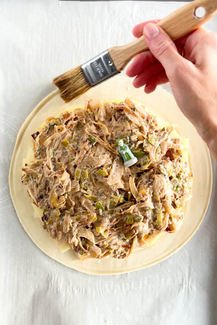 Leek and potato pithivier is comfort food at its finest. This potato pie combines layers of sliced potatoes, Comte cheese, and leeks, all tossed in a golden and flaky puff pastry.