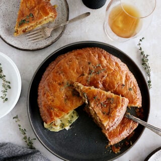 Cette tourte aux pommes de terre est née de l'idée d'une galette des rois salée. On y retrouve des fines lamelles de pommes de terre, du poireau et du Comté entre deux disques de pâte feuilletée.