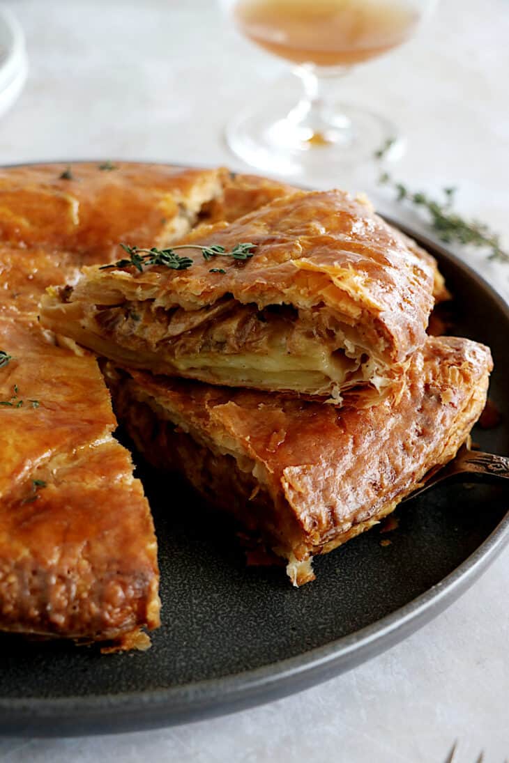 Cette tourte aux pommes de terre est née de l'idée d'une galette des rois salée. On y retrouve des fines lamelles de pommes de terre, du poireau et du Comté entre deux disques de pâte feuilletée.