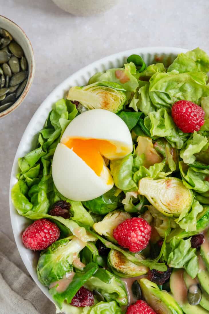 This vibrant avocado raspberry salad with soft-boiled eggs comes with a sweet and subtle raspberry vinaigrette.