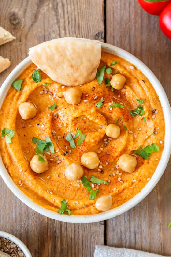 Le houmous aux poivrons grillés est une tartinade aux saveurs douces et fumées, idéale pour l'apéritif avec du pain pita ou des crackers.