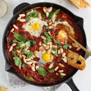 This easy white bean shakshuka features some poached eggs, white beans and baby spinach in a rich tomato sauce.