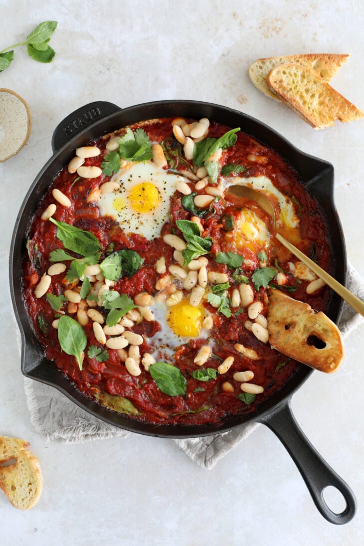 This easy white bean shakshuka features some poached eggs, white beans and baby spinach in a rich tomato sauce.