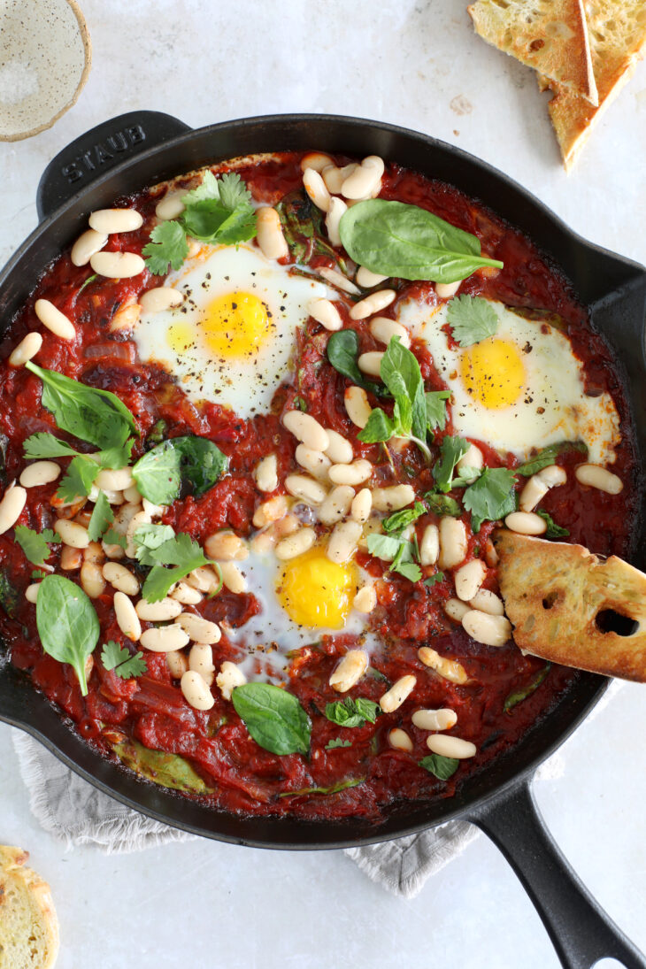 This easy white bean shakshuka features some poached eggs, white beans and baby spinach in a rich tomato sauce.