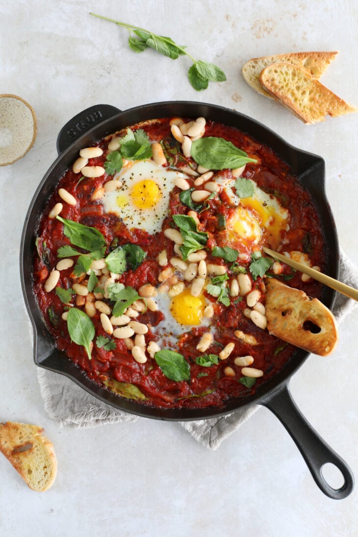 This easy white bean shakshuka features some poached eggs, white beans and baby spinach in a rich tomato sauce.