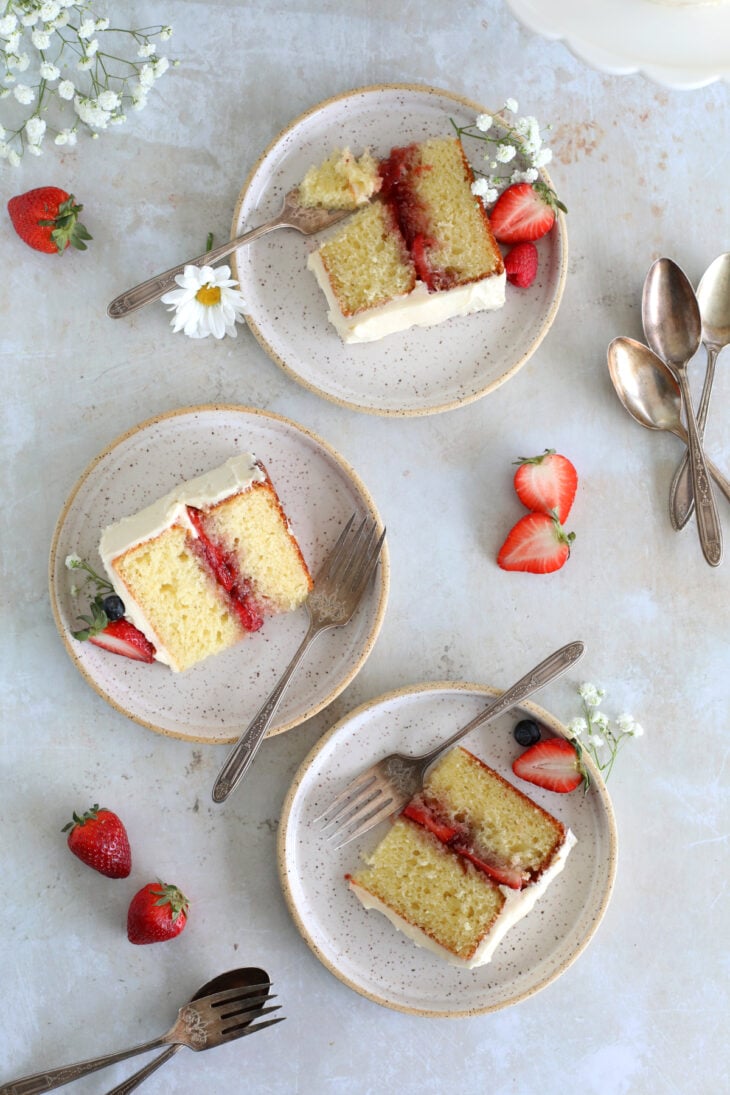 Découvrez mon layer cake aux fraises facile et en petit format 4-6 personnes. Réalisé avec une base de gâteau au yaourt, il est garni de confitures de fraises, de fraises fraîches, et recouvert d'un glaçage à la vanille oncteux. Une recette simplissime qui fait petit effet !