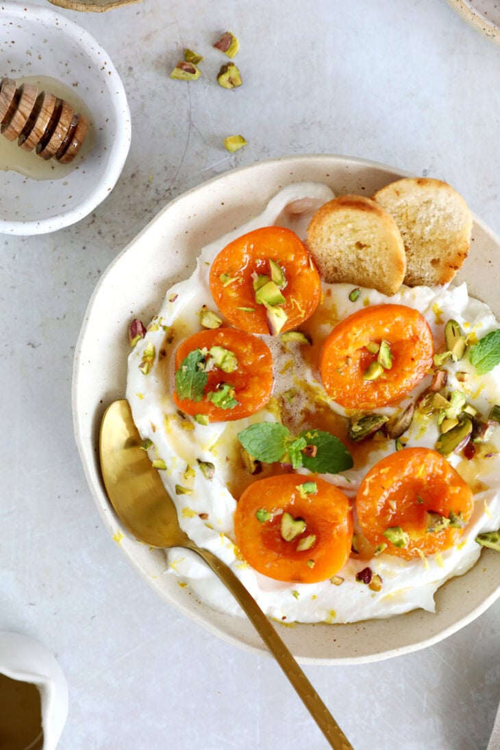 Honey-roasted apricots with whipped ricotta, brown butter and toasted pistachios makes for a simple and elegant summer dessert.