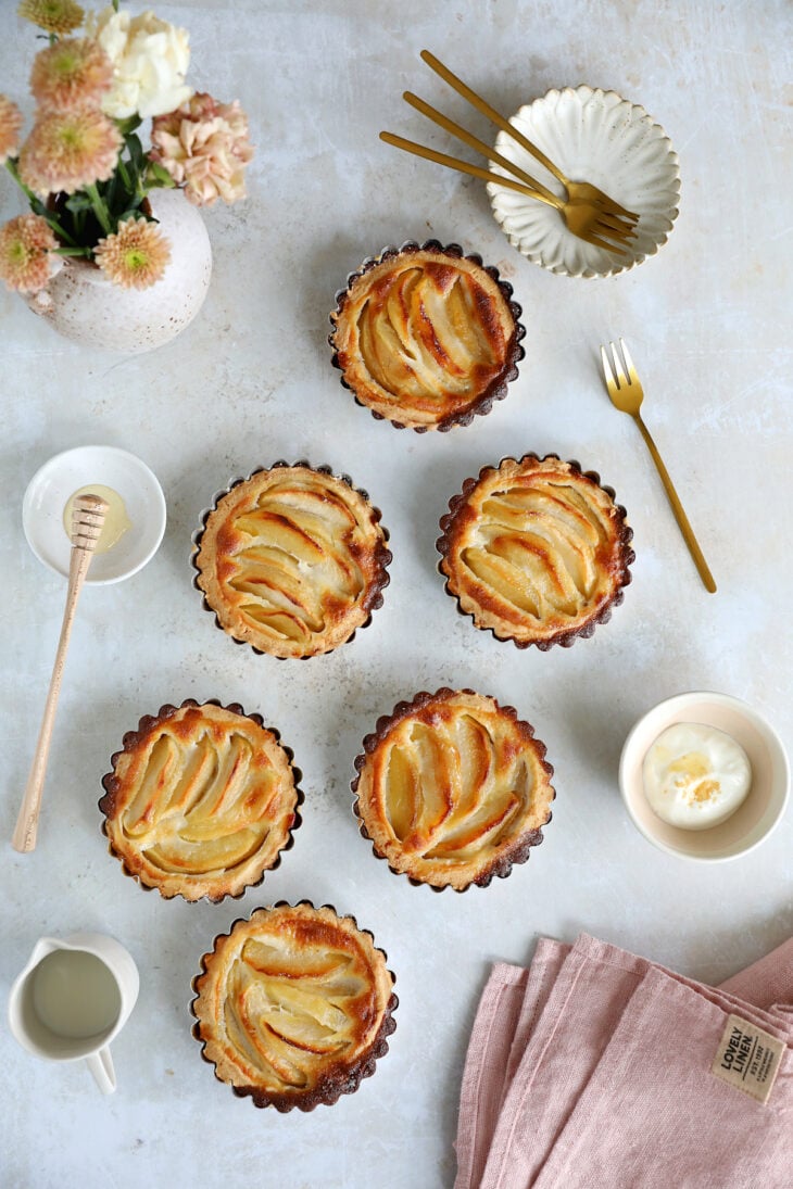 Ces petites tartelettes aux pommes sont aussi jolies que gourmandes. Préparées avec une pâte brisée et une garniture aux pommes fondantes, elles sont parfaites pour le goûter.